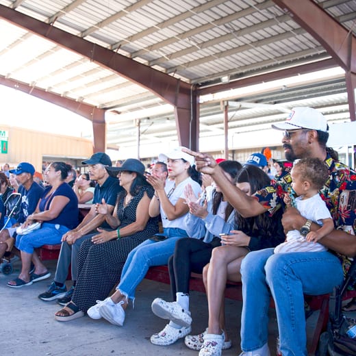 Families seated along the pavilion watching the evening programme.